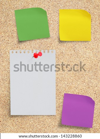 White torn paper note and sticker note with red pushpin on memo board