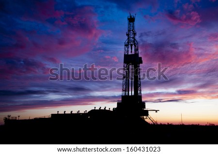 Black silhouette oil rig on dramatic sky background