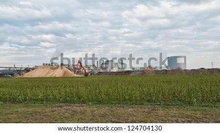 wide angle shot of a sugar mill factory with a sand hill in front
