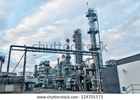 evening view of an oil refinery with cloudy sky and smoking chimneys