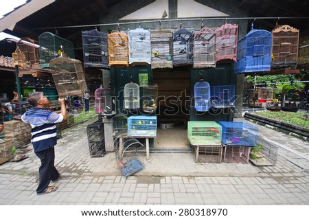 YOGYAKARTA, INDONESIA - JUNE 26, 2014: Undefined man sells birds at the Pasar Ngasem Market, polular known as Bird Market in Yogyakarta, Java, Indonesia on June 26, 2014