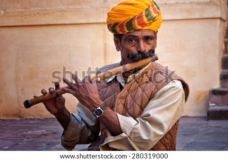 JODHPUR, INDIA - FEBRUARY 28, 2013: Undefined man wearing turban playing on the flute in the Jodhpur fort, India. February 28, 2013