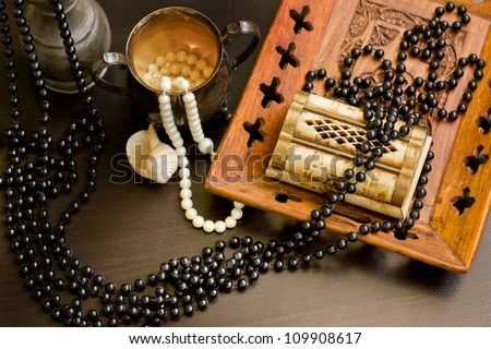 Jewels in a nacreous shell on a dressing table/Still life with wooden treasure chest with pearl necklaces./ pearl necklace and seashell over stones