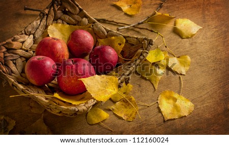 Bushel of red apples and autumn leaves/ Red apples with basket