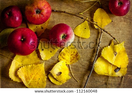 Bushel of red apples and autumn leaves/