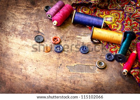Vintage Spools of threads and buttons on old wooden table