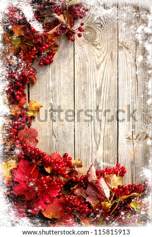 Autumn frame from ashberry and maple leaves on wooden plates with grunge texture/Thanksgivin g day background