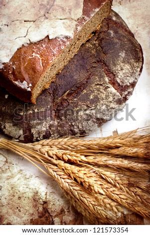 still life with black bread and ears of wheat/composition with natural fresh bread and ears of rye on a vintage background/diet of brown bread/healthy eating