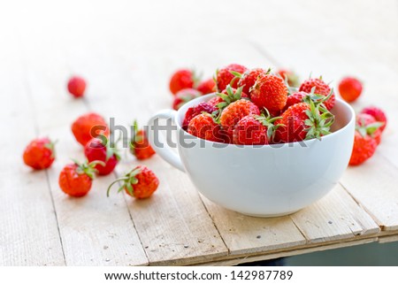 White China Bowl Filled With Succulent Juicy Fresh Ripe Red Strawberries On Wooden Table Top