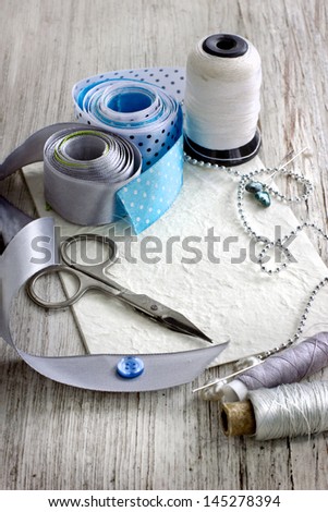 Scrapbooking craft materials/Backgroun d with sewing tools and colored tape/Sewing kit. Scissors, bobbins with thread and needles on the old wooden background