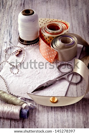 Scrapbooking craft materials/Backgroun d with sewing tools and colored tape/Sewing kit. Scissors, bobbins with thread and needles on the old wooden background