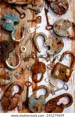 vintage background with locks and lots of keys on wooden table with grunge texture