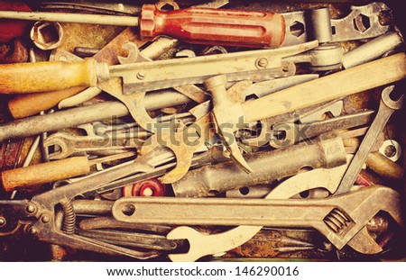 Dirty set of hand tools on a wooden panel/vintage background with a tools