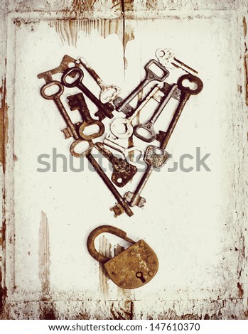 vintage background with locks and lots of  keys on wooden table with grunge texture/Heart from keys