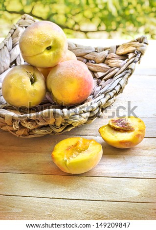 Peaches spilling out of a basket/Ripe sweet peaches on wooden table