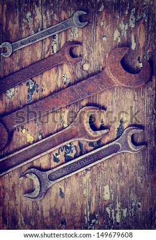 Dirty set of hand tools on a wooden panel/vintage background with a tools