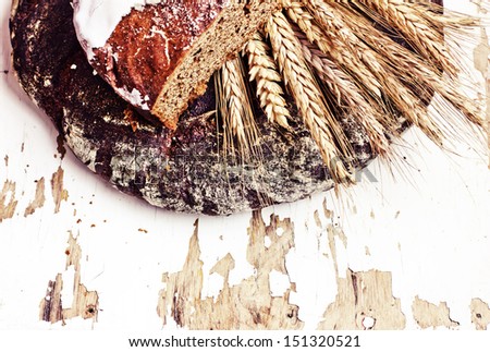 still life with black bread and ears of wheat/composition with natural fresh bread and ears of rye on a vintage background/diet of brown bread/healthy eating