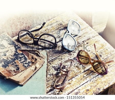 Close-up of opened book pages and glasses against vintage background/Vintage books with reading glasses in an used bookstore