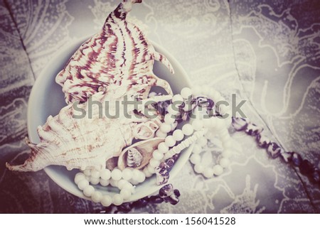 Vintage pearl necklaces and seashell with grunge texture
