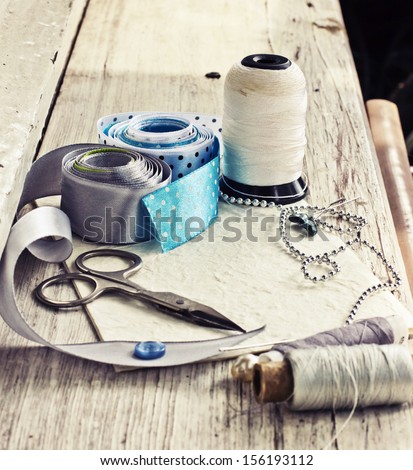 Scrapbooking Craft Materials/ Background With Sewing Tools And Colored Tape/Sewing Kit. Scissors, Bobbins With Thread And Needles On The Old Wooden Background