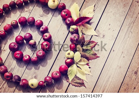 Vintage Autumn border from apples and fallen leaves on old wooden table/Thanksgiving day concept/background with apples