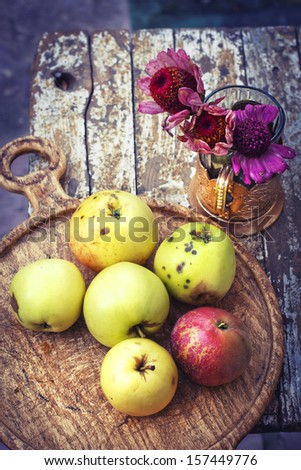 Autumn border from organic apples and flowers on old wooden table. Thanksgiving day concept