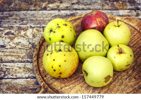 Autumn border from organic apples and flowers on old wooden table. Thanksgiving day concept