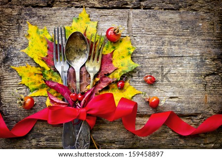 Thanksgiving table setting/ cutlery on the autumn background with  autumn leaves,ribbon on wooden abckground/Thanksgiving holidays background concept
