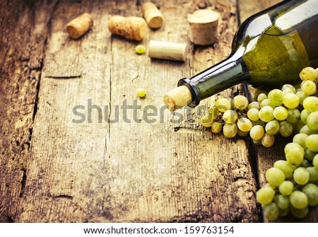 Wine bottle , grape and corks on wooden table / summer wine background