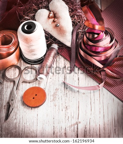 Scrapbooking craft materials/ Background with sewing tools and colored tape/Sewing kit. Scissors, bobbins with thread and needles on the old wooden background