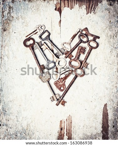 vintage background with locks and lots of keys on wooden table with grunge texture/Heart from keys