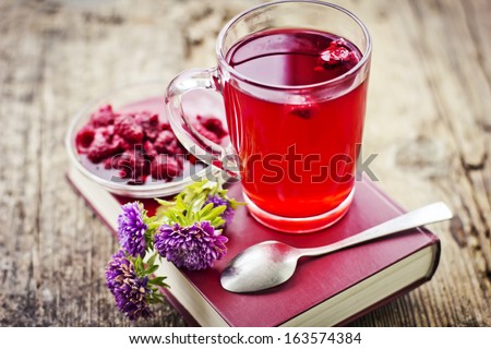 Raspberry jam tea/Romantic Autumn background with raspberry hot drink ( fruit tea) and flowers