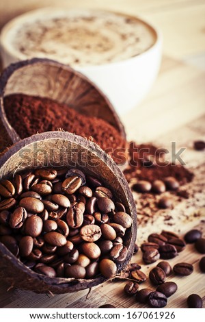 Cocos Bowls With Coffee Beans And Ground Coffee Over Wooden Background