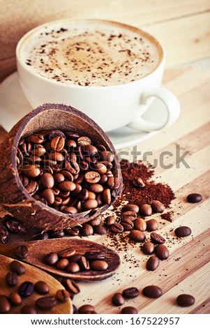 Cocos Bowls with coffee beans and ground coffee over wooden background