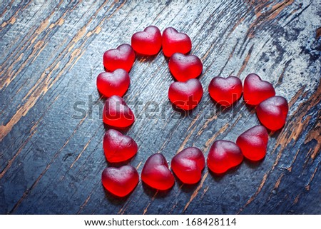 Red Valentines Day heart shaped candy border on dark  texture wooden background