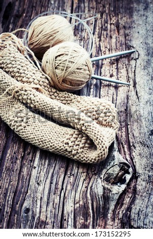 Knitting needles and yarn on rustic wooden background/ natural wool knitting background