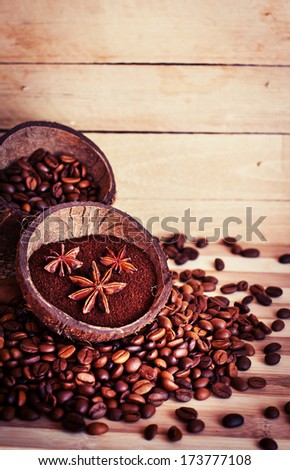Cocos Bowls with coffee beans and ground coffee over wooden background