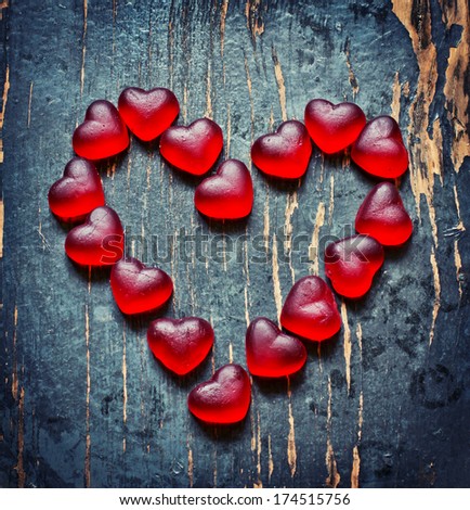 Red Valentines Day heart shaped candy border on dark texture wooden background