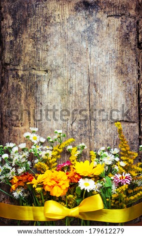 colorful floral frame on rustic wooden background/spring or summer background