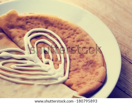 Pancakes with with heart fom sour cream closeup on a plate for pancake day
