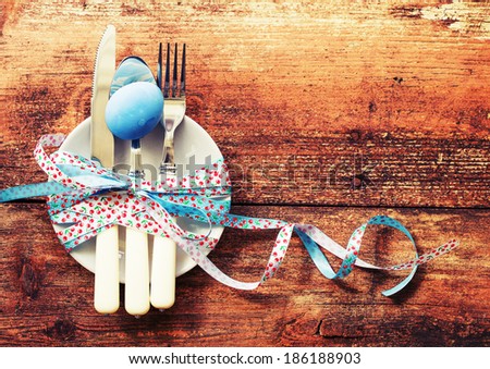Easter table setting with white plate and easter egg  on old wooden table/ Easter background