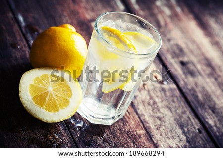 Lemonade with fresh lemon on wooden background