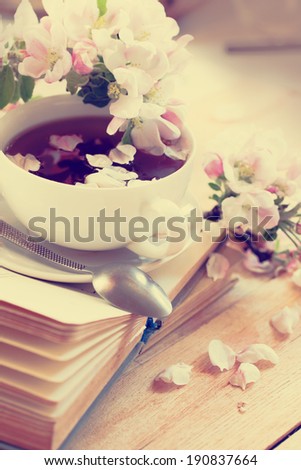 Books, flowers and  cup of tea and bookson wooden table