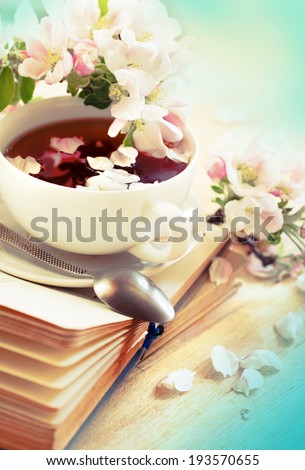 Books, flowers and cup of tea on wooden table