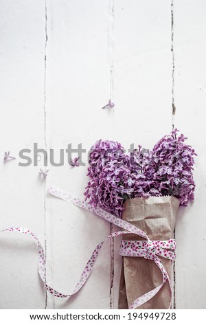 Bouquet of lilac spring flowers on light shabby chic background