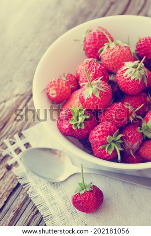 ripe red strawberries on an old wooden textured table