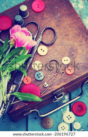 Vintage Background with sewing/Sewing kit. Scissors, bobbins with thread and needles on the old wooden background