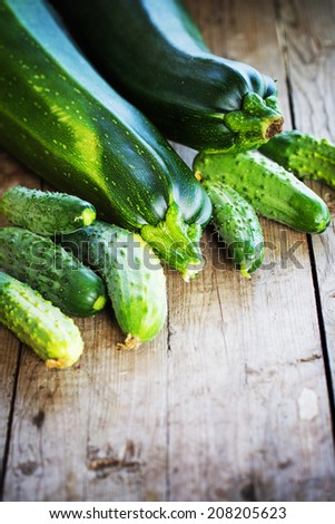 Set of green fruits and vegetables. Zucchini and cucumbers on wooden table