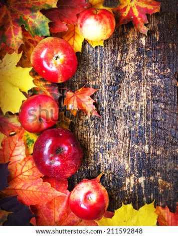 Vintage Autumn border from apples and fallen leaves on old wooden table/ Thanksgiving day concept/ background with apples