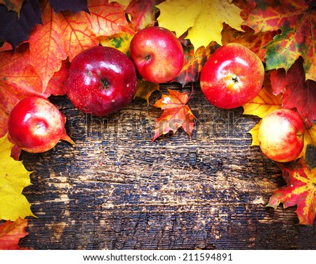 Vintage Autumn border from apples and fallen leaves on old wooden table/ Thanksgiving day concept/ background with apples